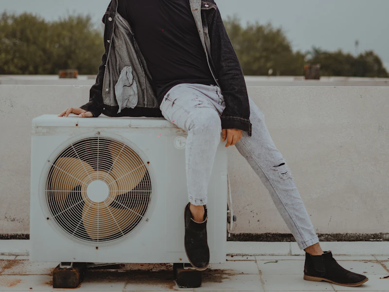 HVAC tech next to an outdoor condenser unit